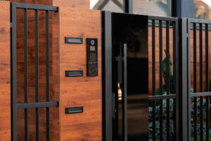 Modern wooden and metal residential gate featuring a built-in intercom system for enhanced security